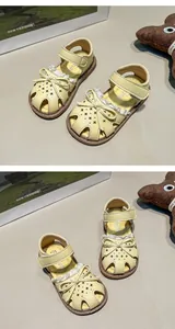 Detailed view of yellow closed-toe girl's sandals with bow tie and star hollow design