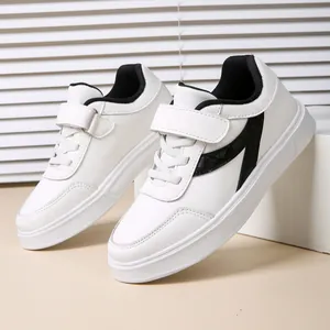 Detailed close-up view of white student skate shoes featuring black accents and velcro strap