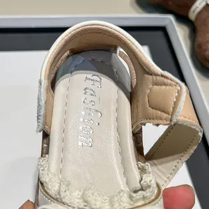 Close-up detail of cream girls summer sandals featuring a silver Fashion logo on the insole