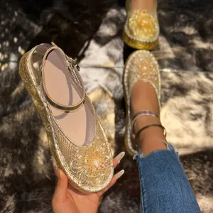 Gros plan sur une chaussure Mary Jane dorée en mesh avec des motifs floraux complexes