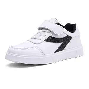 Stylish white children's sneakers with black geometric design and velcro strap fastener