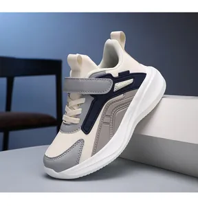 Detailed side view of breathable kids sports sneakers in cream, grey and navy blue.