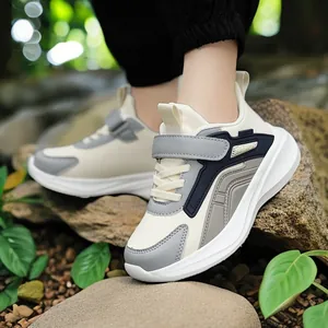 Children's breathable running shoes with velcro strap and stylish grey-beige colorway.