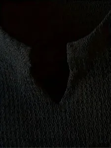 Close-up macro detail of black breathable textured fabric with V-neck cut for sports men