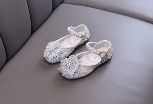 Close-up of sparkling rhinestone snowflake ornament and pearl straps on girl's dress shoes