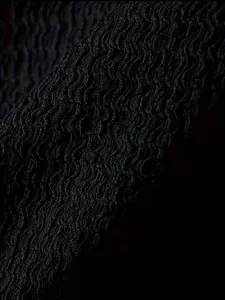 Close-up macro view of breathable wavy textured fabric on black men's sports vest