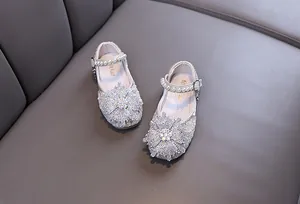 Detailed shot of girls' sparkly rhinestone princess dress shoes with pearl straps