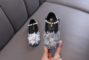 Detail of sparkly rhinestone girls princess shoes with pearl strap for dance