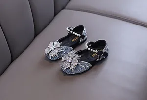 Detail shot of girls rhinestone princess shoes with pearl strap and flower ornament