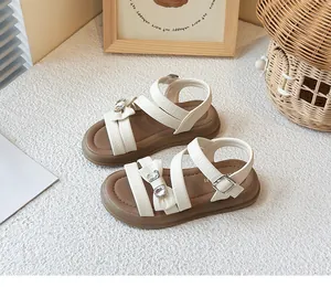 Close-up view of girls cream princess sandals featuring elegant bow and crystal details
