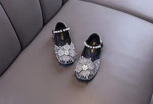 Close-up of girls' princess shoes with sparkling rhinestones and pearl straps.