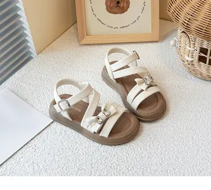 Detailed view of white girls' princess sandals with elegant bow and rhinestone accents