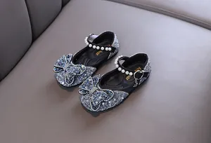 Detail view of sparkly blue glitter girls' princess shoes with pearl straps and bow