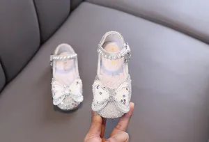 Detailed view of sparkly silver girls' princess shoes with bow and pearl strap