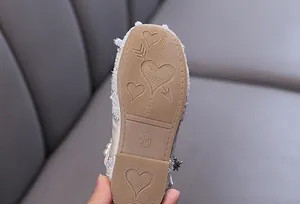 Detailed macro view of heart patterned anti-slip rubber sole on girls rhinestone dress shoe