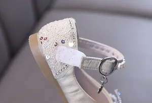 Close-up detail of girl's princess shoe with sequins, rhinestones and velcro strap