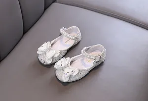 Detailed view of white sparkling princess shoes for toddler girls with pearl bows