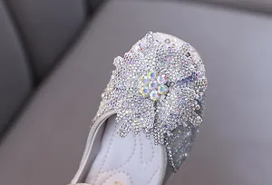 Close-up of sparkling silver rhinestone snowflake detail on princess shoes for girls.