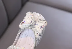 Macro view of glittering rhinestone bow and pearls on elegant girl's princess dress shoe