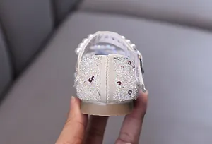 Detailed macro view of the sparkling sequin heel and pearl strap on girl's princess shoes