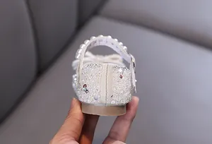 Detailed macro view of girl's princess shoe heel with sparkling sequins and pearl strap