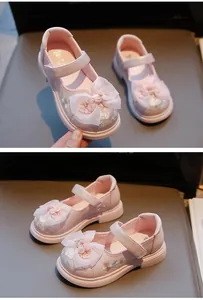 Detail view of pink girl's Hanfu style embroidered shoes with mesh bow decoration