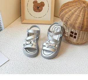 Silver girl's princess sandals with bow and rhinestone details in a cozy setting