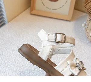 Close-up detail of white girl's princess sandal with bow and sparkly rhinestone buckle