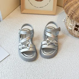 Elegant silver girls sandals with sparkling bow detail and crossed straps for summer