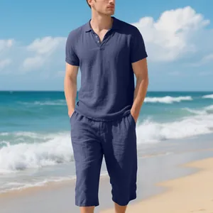 Close-up detail of men's navy blue linen polo and cropped pants set on a sunny beach