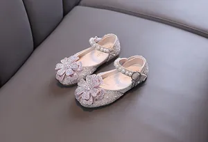 Detailed view of sparkling girl's princess shoes with rhinestone flower and pearls