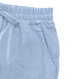 Close-up detail of men's blue linen pants showing elastic waist and drawstring.