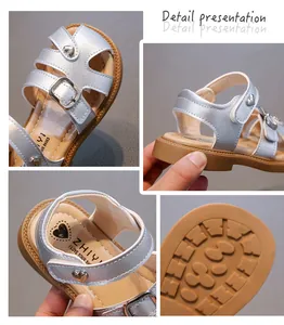 Close-up of silver girls' sandals showing heart buckle detail and anti-slip rubber sole