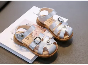 Close-up detail of stylish silver toddler girl sandals featuring heart-shaped charms
