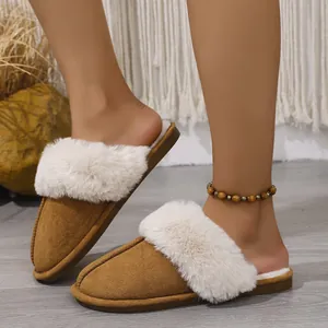Cozy brown suede house slippers featuring soft white faux fur trim worn in a warm home.