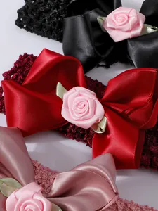 Detalle de diademas de lazo de satén de princesa con rosas de tela para recién nacidos