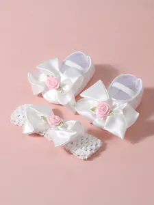 Elegantes zapatos de bebé de satén blanco y diadema de encaje a juego con rosas rosas