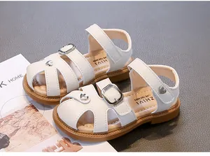 Detailed close-up of white girls' closed-toe sandals with heart charms and soft soles