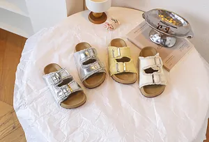 Kinder-Birkenstock-Sandalen mit Fransen und Doppelschnallen in Silber, Gelb und Weiß.
