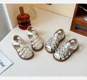 Top view of two pairs of girls' Lolita sandals in cream white and metallic silver colors