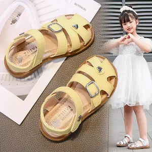 Yellow hollow-out girl's sandals with buckle straps and heart-shaped metal charms