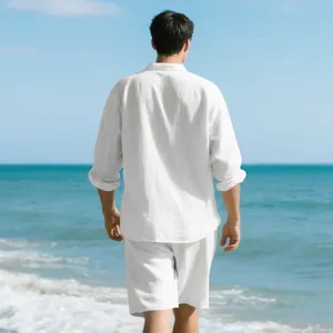 Rear view of a man wearing a white loose linen shirt and shorts set on a sunny beach