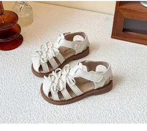 Close-up detail of white Lolita style girls sandals featuring sweet bow decorations