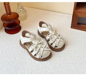 Detailed view of white girl's Lolita sandals featuring elegant bow knots and closed-toe design