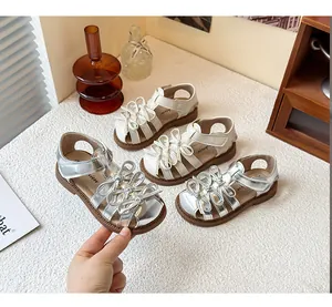 Close-up detail of silver and white Lolita-style girl's sandals with delicate bows.