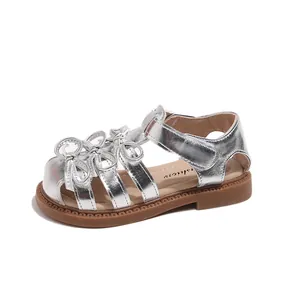Side profile of silver toddler girl's princess sandal with bow and strap