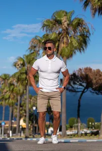 Man wearing a white ribbed slim fit short sleeve polo shirt in an outdoor tropical setting