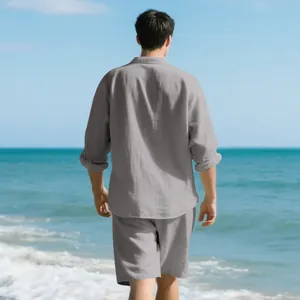 Back view of men's grey linen long sleeve shirt and shorts beach set on a beach