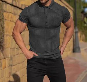 Detailed view of dark grey ribbed knit short sleeve polo shirt on athletic model.