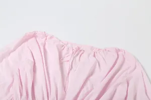 Dettaglio dello scollo rotondo rosa chiaro con una delicata chiusura a laccetto regolabile